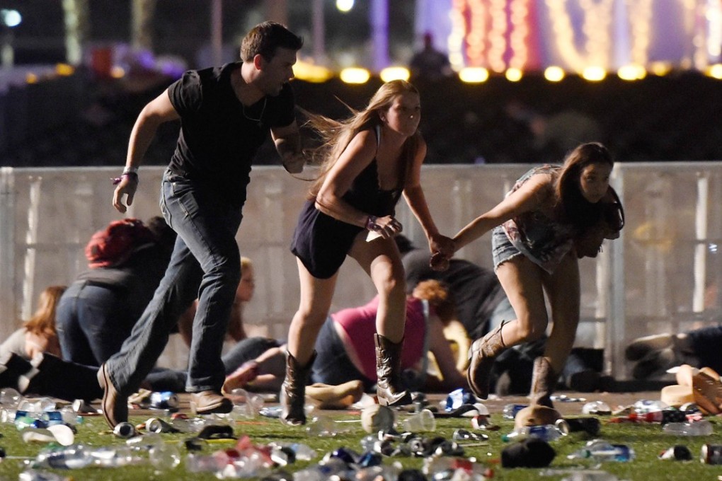 People run to escape from the Route 91 Harvest country music festival after a gunman opened fire on the event in Las Vegas on Sunday night. Photo: AFP