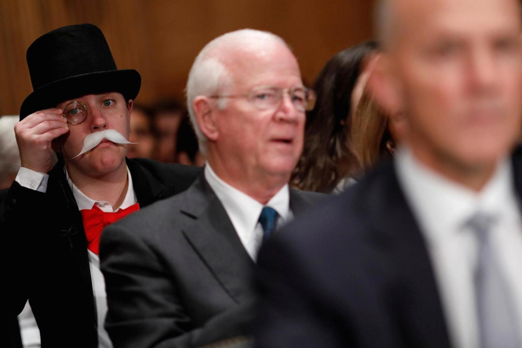 A hearing attendee dressed as Monopoly's Uncle Pennybags looks on as Richard Smith, former chairman and CEO of Equifax, Inc., testifies before the U.S. Senate Banking Committee on Capitol Hill in Washington, U.S., October 4, 2017. Photo: Aaron P. Bernstein/Reuters