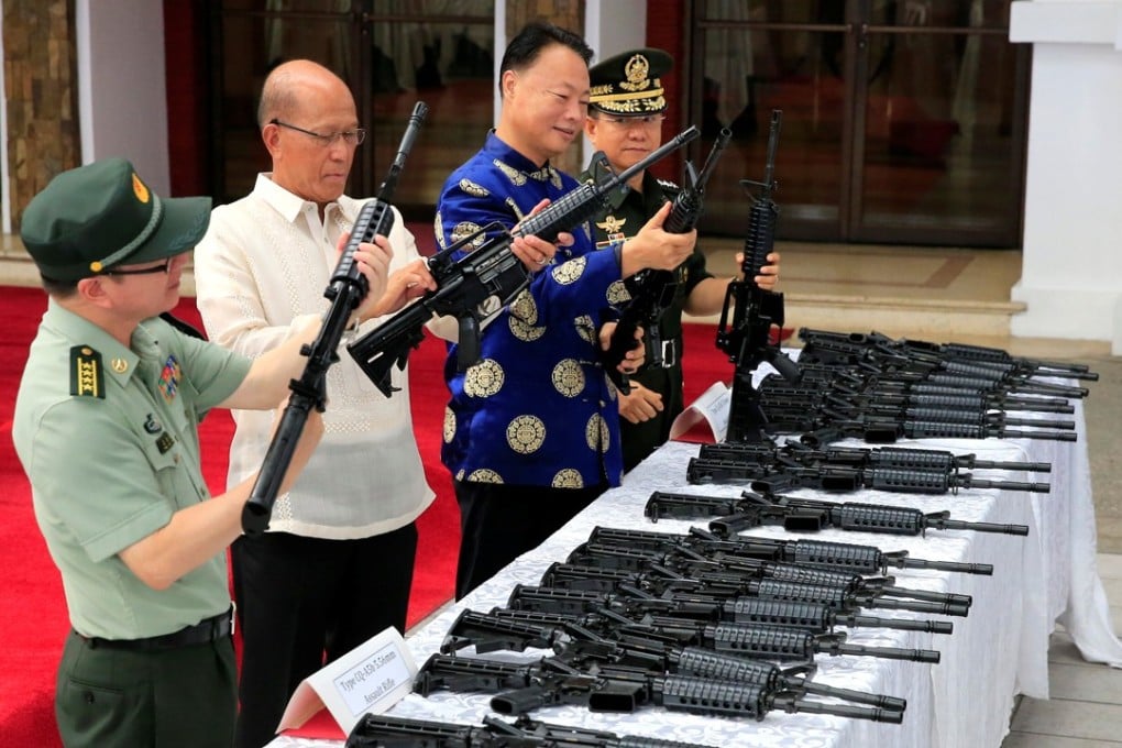 Philippine Defence Secretary Delfin Lorenzana (second from left) and Chinese ambassador the Philippines Zhao Jianhua (second from right) inspect automatic rifles during a handover of military supplies at Camp Aguinaldo in Quezon city. Photo: Reuters