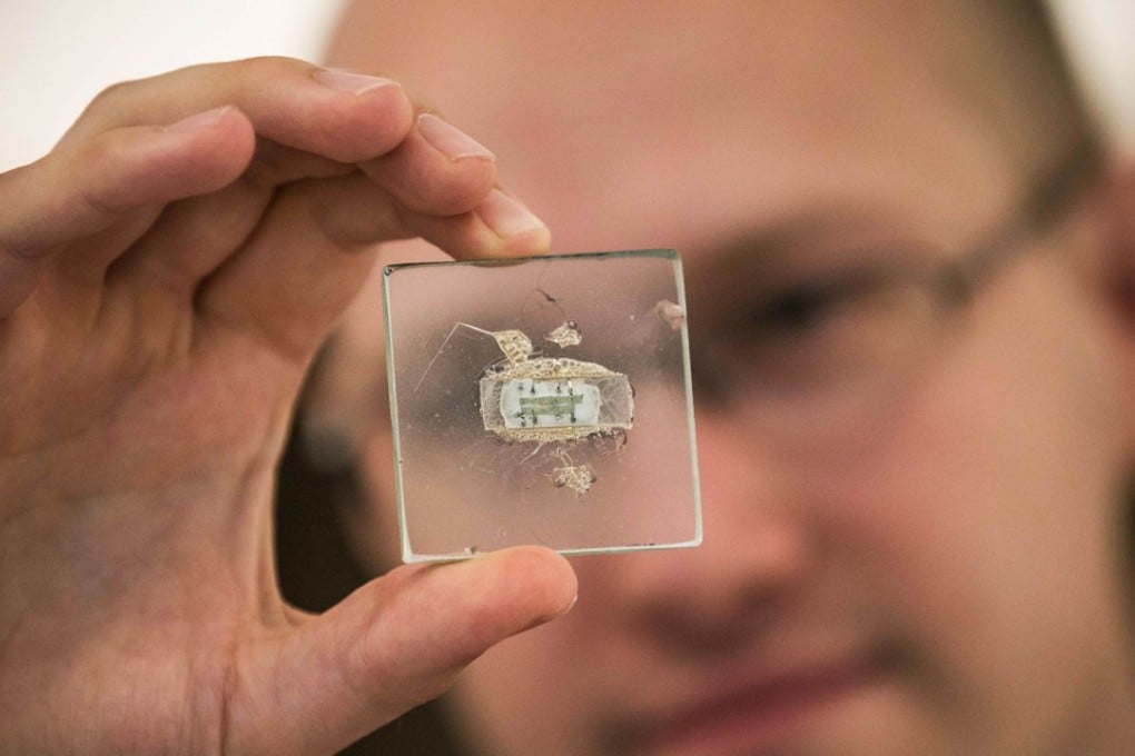 Jack Hyslop, science specialist for Christie's, displays a 1958 prototype of a microchip before auction on June 17, 2014 in New York City. The microchip helped inventor Jack Kilby win the Novel prize. Photo: AFP
