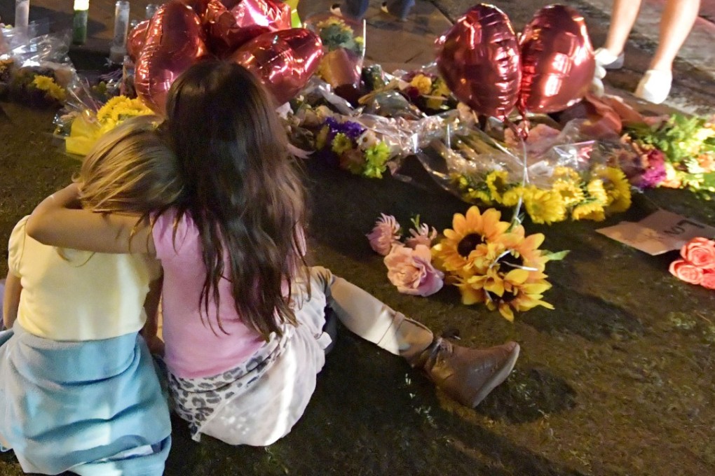 Children join hundreds of mourners who paid their respects to the victims of Sunday night’s mass shooting in Las Vegas, which left 58 dead. Photo: Kyodo