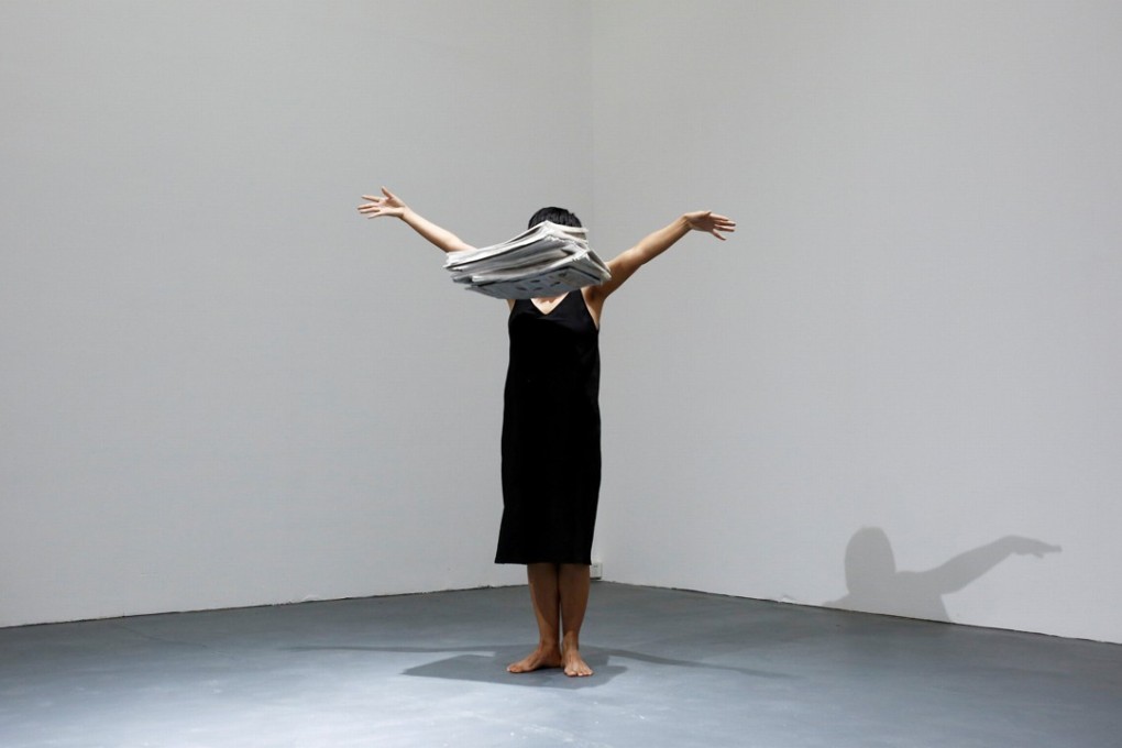 Performance artist Yi Fei drops a pile of newspapers as she performs her piece No News at the OPEN international performance art festival. Photo: Reuters