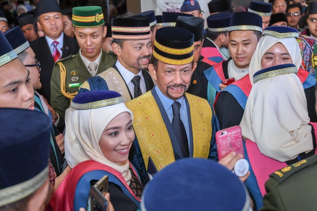 Brunei's Sultan Hassanal Bolkiah poses for photos with a student of Brunei Darussalam University after a graduation ceremony held in Bandar Seri Begawan, the capital of Brunei. The sultan is celebrating 50 years on the throne on Thursday. Photo: Xinhua