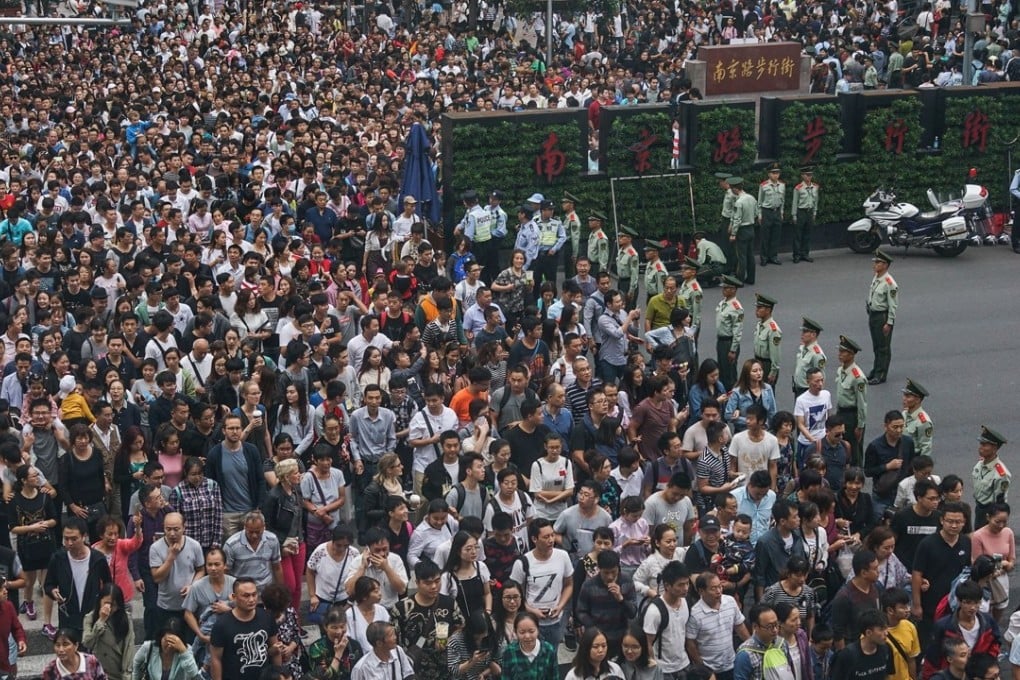 Chinese security personnel keep watch on pedestrian traffic during the week-long 'Golden Week' holidays at a zebra crossing in Shanghai on October 3, 2017. Photo: AFP
