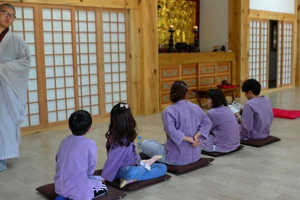 A monk leads a temple stay group at the Beomeosa Temple, near Busan, in the proper ways and means of meditation. Photo: Andrew Sun