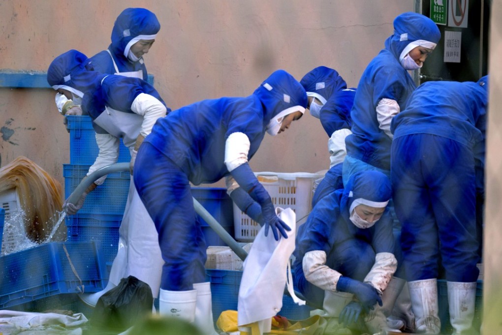 North Koreans wash up after work at a seafood processing plant in Hunchun, northeast China. Photo: AP