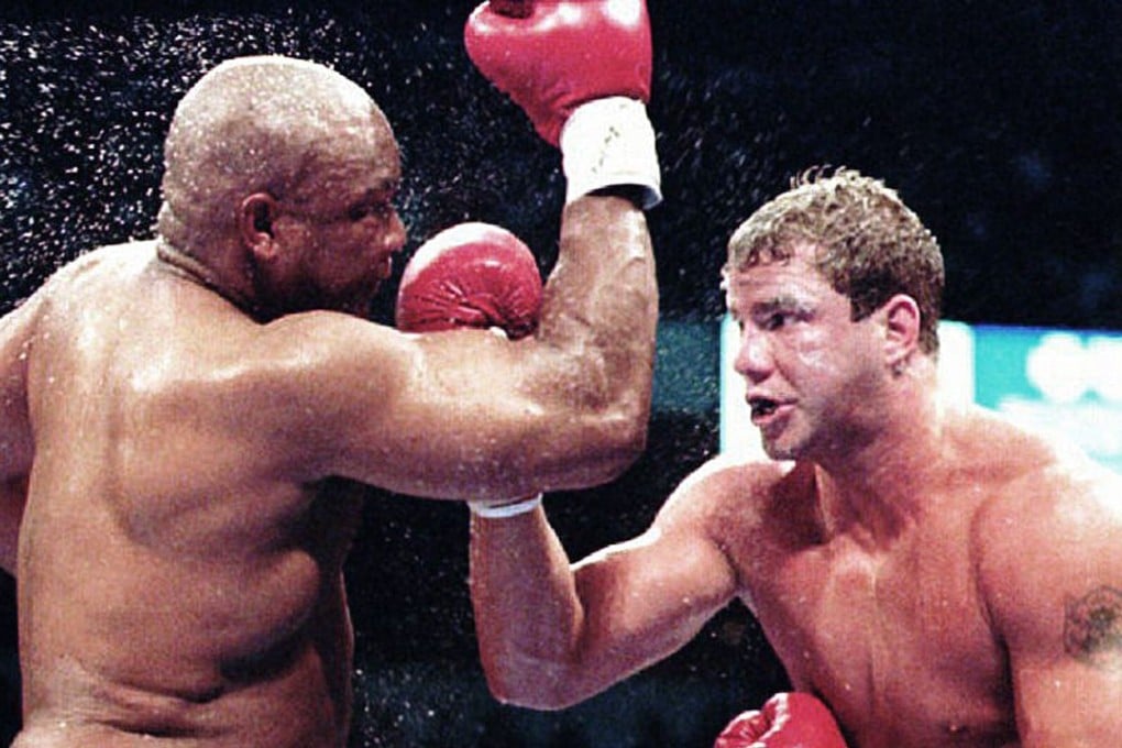 Tommy Morrison lands a punch against American George Foreman during their heavyweight title bout in 1993. Morrison won the fight to become WBO heavyweight champion. Photo: AFP