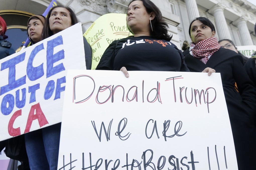 Protesters hold signs as they listen to speakers at a rally outside City Hall in San Francisco, California. California Governor Jerry Brown signed legislation, SB54, that extends protections statewide for immigrants living the United States illegally, on Thursday, October 5, 2017. Photo: AP
