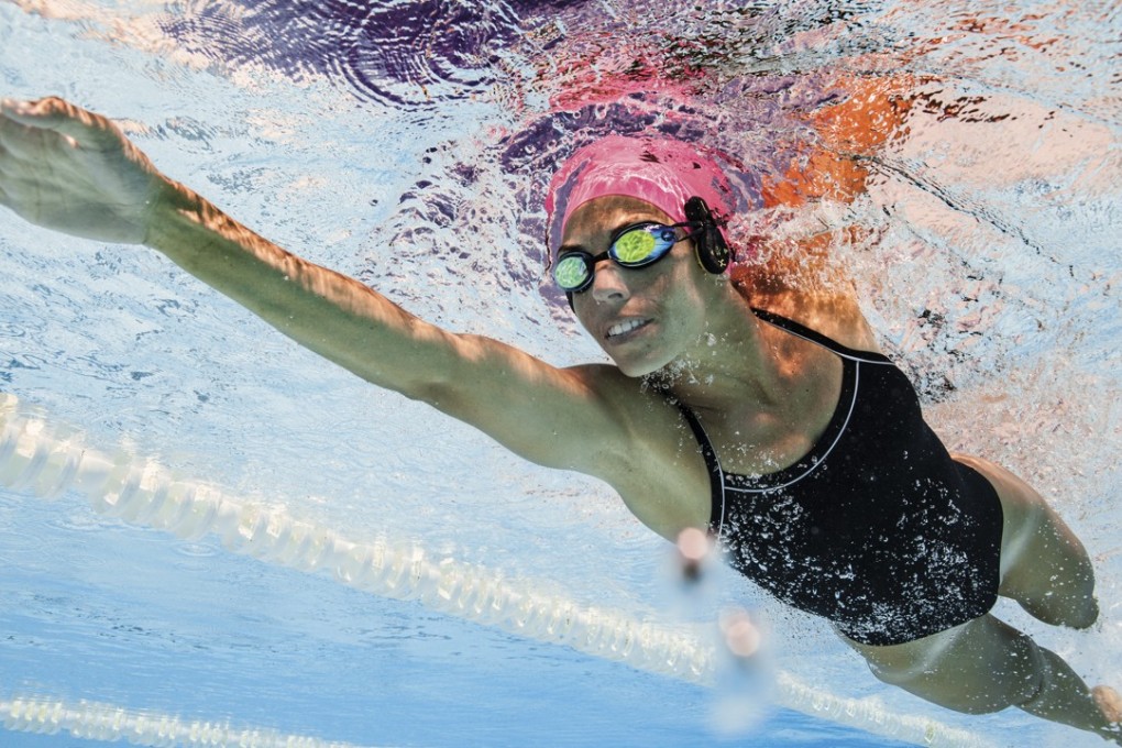 A swimmer wears Finis Duo earphones.