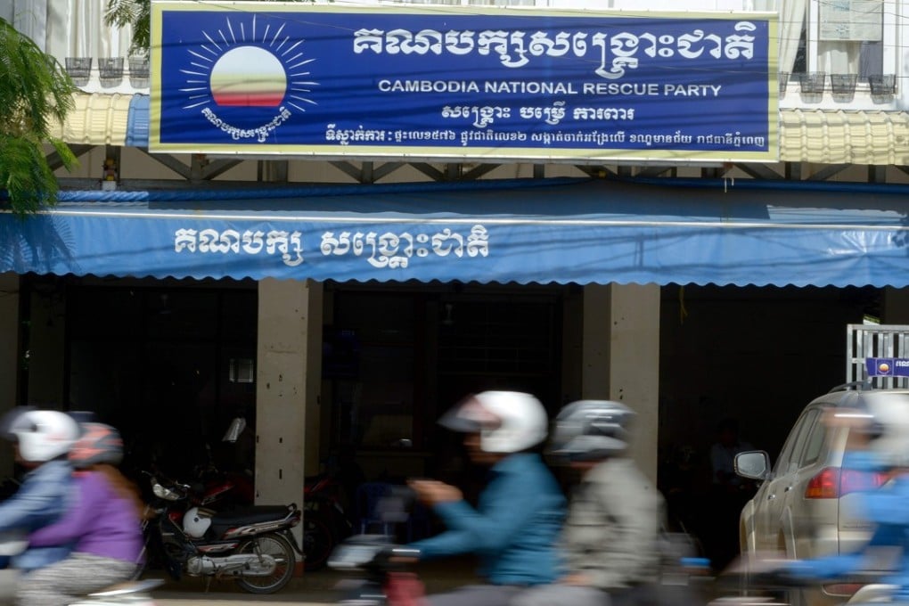 Motorbikes speed past the headquarters of the Cambodia National Rescue Party in Phnom Penh, Photo: AFP