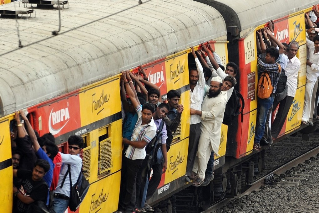 Commuters hang onto an overcrowded suburbun railway train in Mumbai. Photo: AFP
