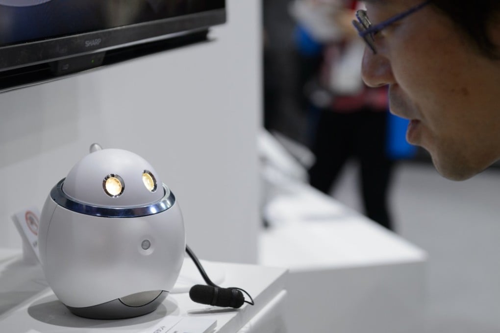 An employee demonstrates Sharp's Home Assistant smart robot prototype at the company's booth at the CEATEC Japan 2017 exhibition in Chiba, Japan. CEATEC is an information technology and electronics trade show. Photo: Bloomberg