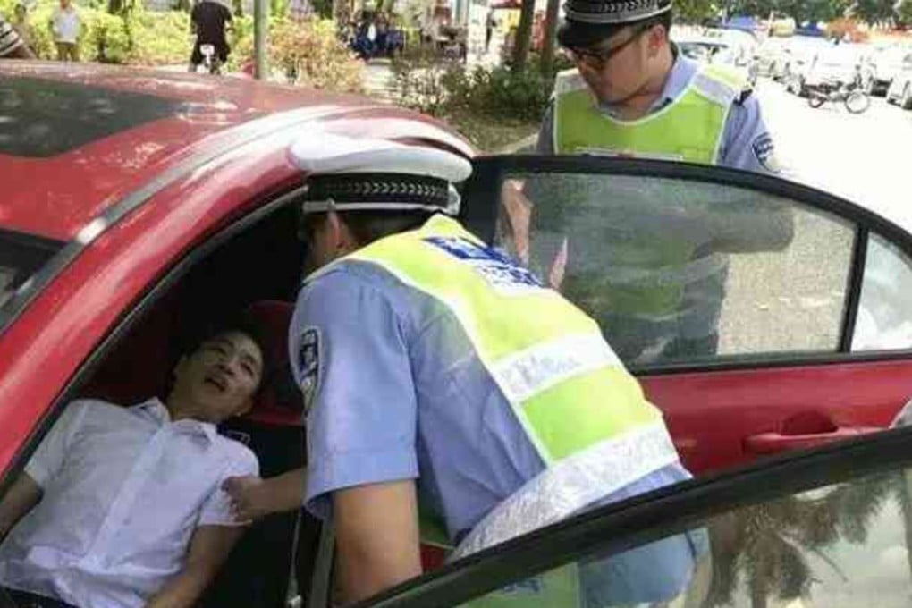 Traffic police assist a driver who fainted while he was stuck in traffic on the Humen Pearl River Bridge in Guangdong. Photo: Gmw.cn
