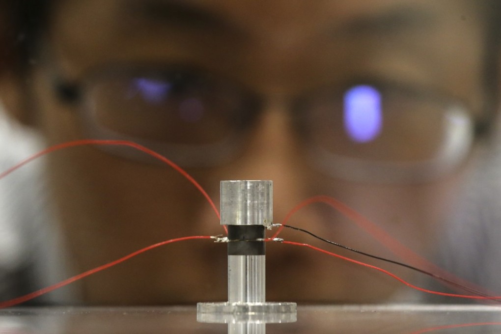 Assistant Professor Guo Ping demonstrates a prototype of the levitating device at CUHK. Photo: Dickson Lee