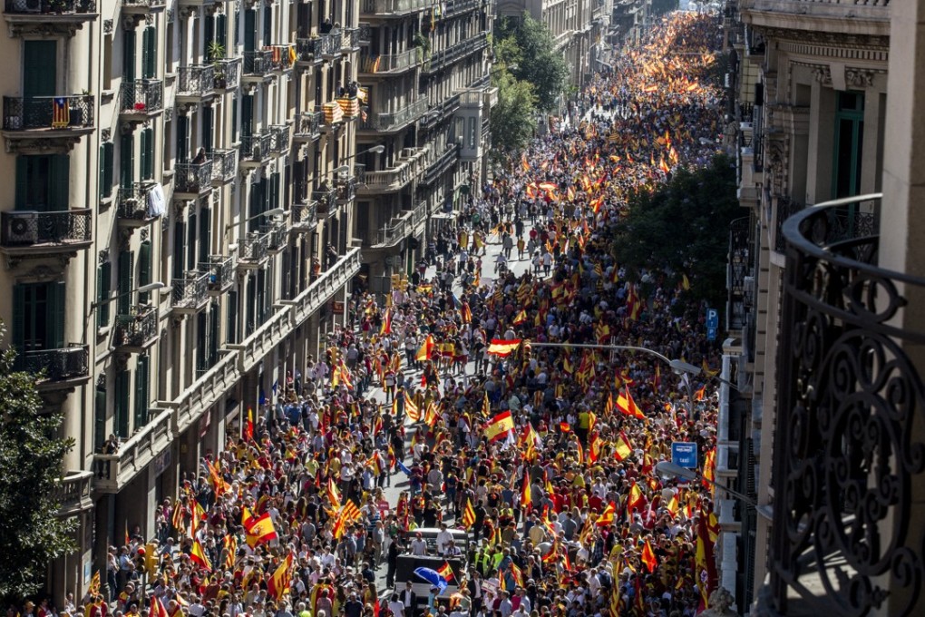 Demonstrators wave Spanish flags during a protest against Catalonia’s independence in Barcelona. Photo: Bloomberg