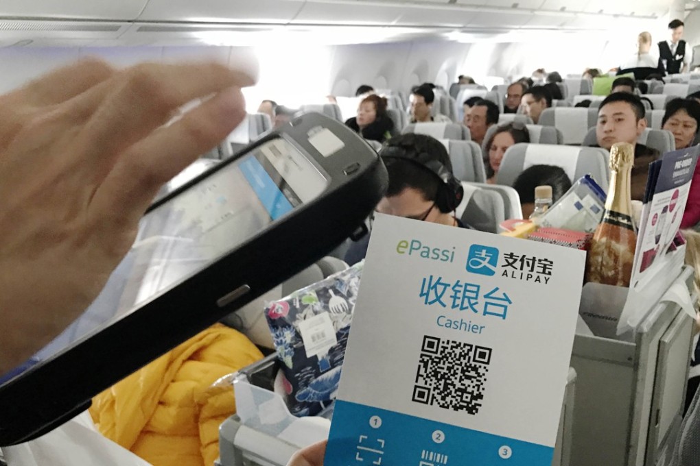 A flight attendant collects payment by Alipay on a flight bound for Helsinki from Beijing. A report by CapGemini and BNP Paribas predicts that China will become the world’s top market for digital payments by 2020. Photo: Xinhua