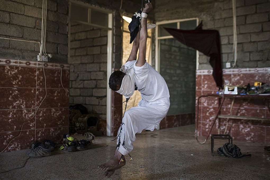 A photo taken by Ali Arkady in late 2016 shows a prisoner of Iraqi forces outside Mosul, strung up by his wrists. Photo: Ali Arkady