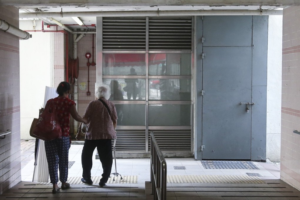A woman helps an elderly person at Pak Tin Estate in Shek Kip Mei. Photo: K. Y. Cheng