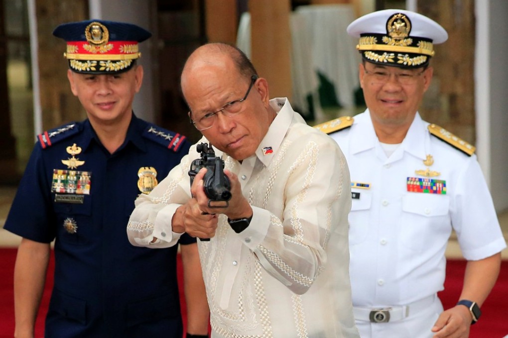 Philippine Defence Secretary Delfin Lorenzana inspects a rifle given to the Philippines by China. Photo: Reuters