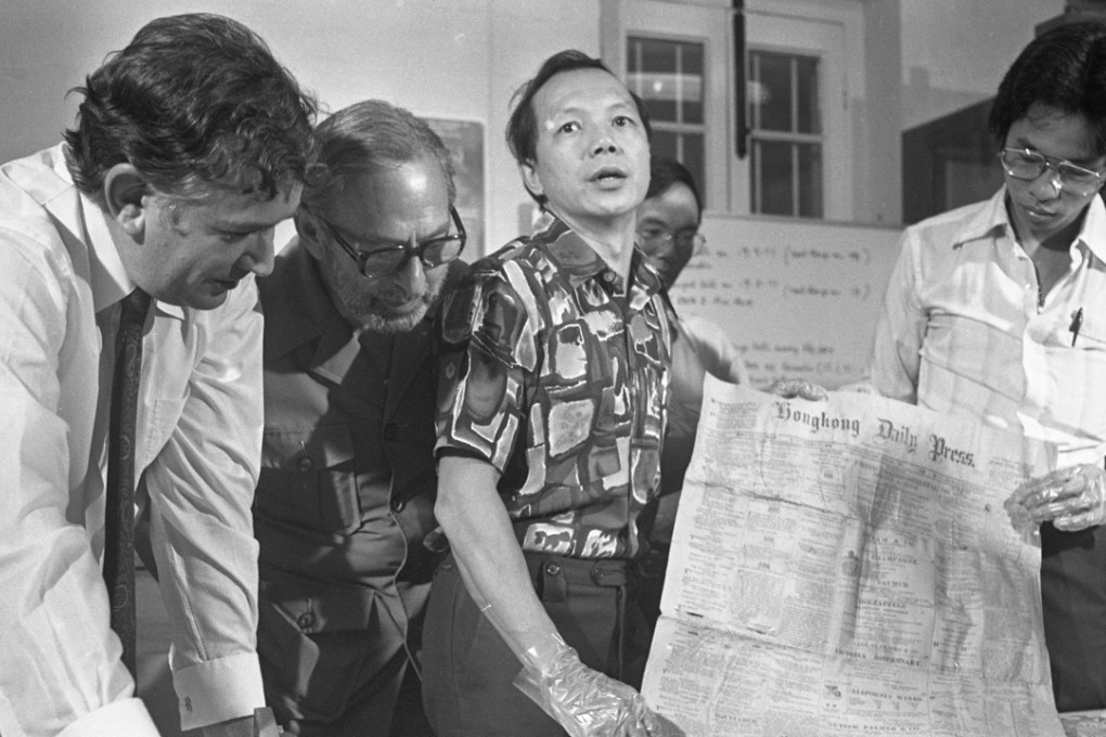 Brian Peacock (left), curator of the Museum of History, and his colleagues (from second left) Solomon Bard, Bobby Ng and Gary Ning examining a copy of a newspaper which was found inside a time capsule sealed in 1897. Photo: SCMP