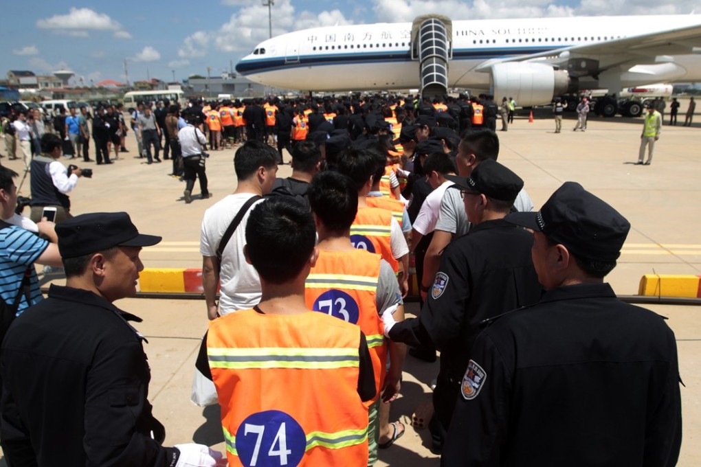 Chinese citizens who have been arrested over an alleged internet scam line up at the international airport in Phnom Penh, Cambodia, to be sent back to China, on Thursday. Photo: AP