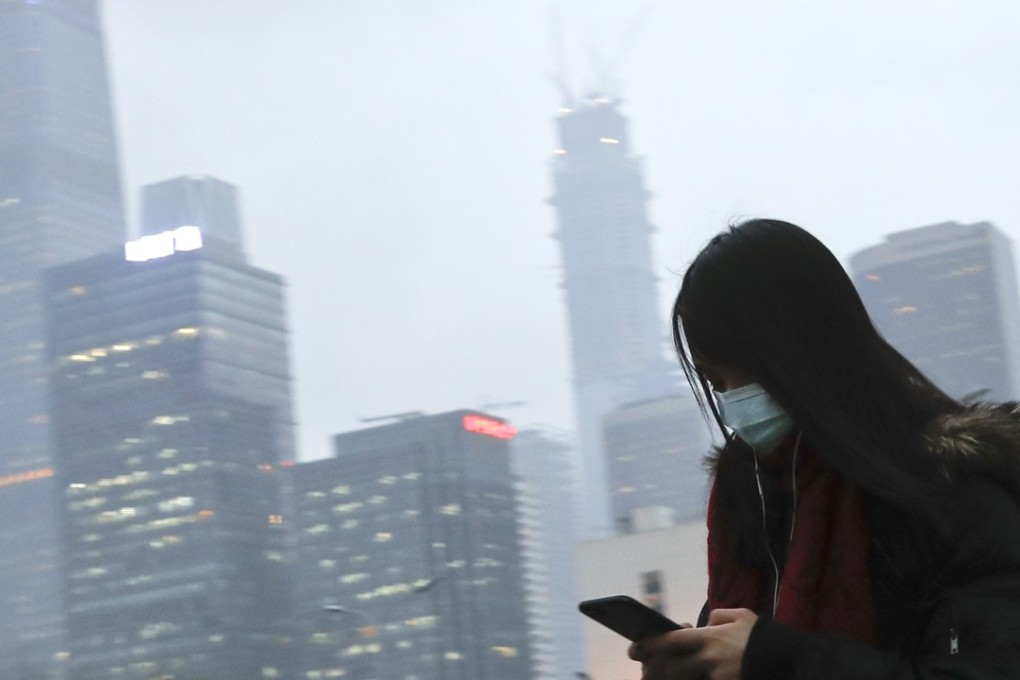 A woman wears a face mask on a grey day in Beijing. Authorities in Shanxi have set targets to reduce concentrations of harmful PM2.5 particles and sulphur dioxide levels by 40 per cent over the winter months. Photo: AP