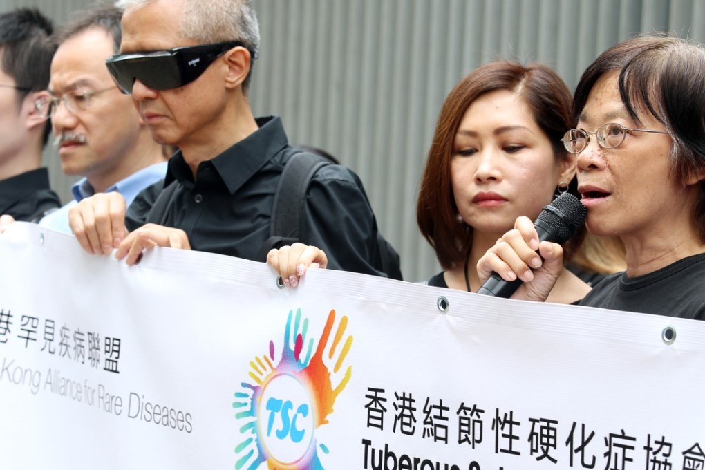 The president of the Hong Kong Alliance for Rare Diseases, Tsang Kin-ping (wearing glasses), Rebecca Yuen Pui-ling, from the Tuberous Sclerosis Complex Association of Hong Kong (second from right), and patient Kong Wong Fung-ming rally outside the government headquarters in Tamar, calling on the Hospital Authority to subsidise drugs for rare diseases. Photo: David Wong
