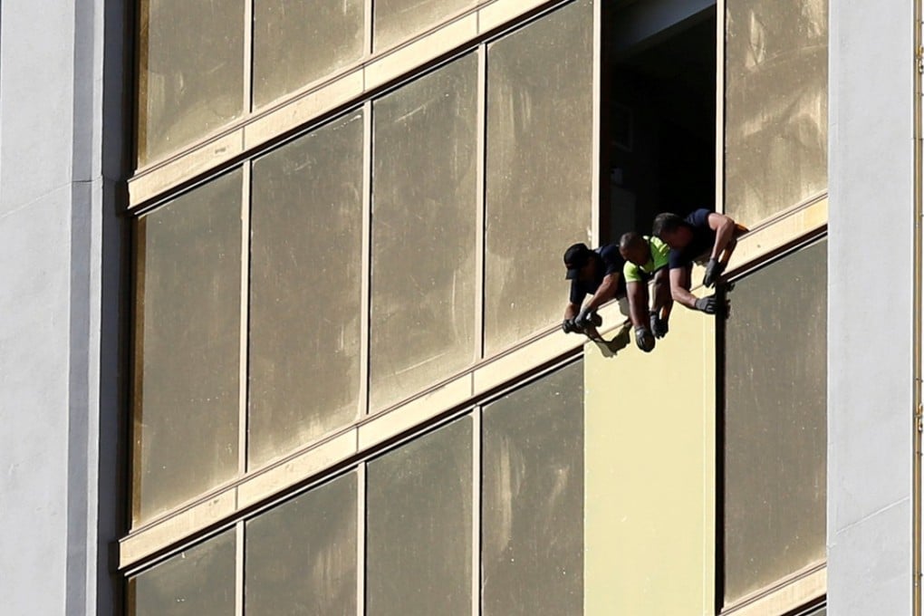 Workers board up a broken window at the Mandalay Bay hotel, from where Stephen Paddock conducted his mass shooting along the Las Vegas Strip. Photo: Reuters