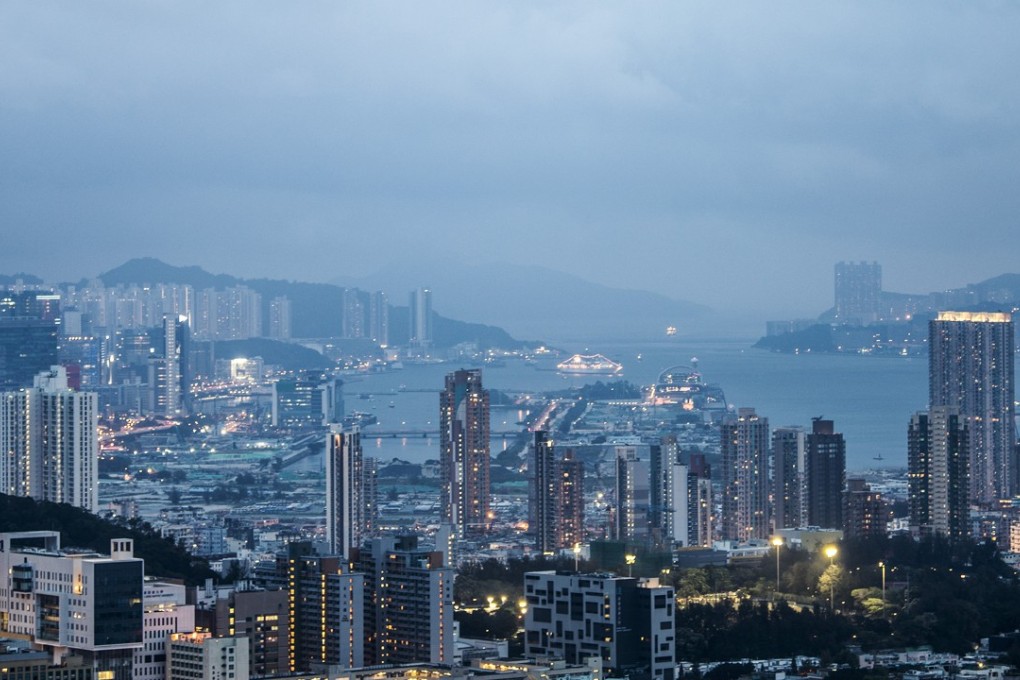 Residential buildings stand illuminated around the former Kai Tak airport area, centre, at dusk in Hong Kong, in June. Hong Kong officials should keep one core principle in mind: it should be the government, not developers, that dictates land supply. Photo: Bloomberg