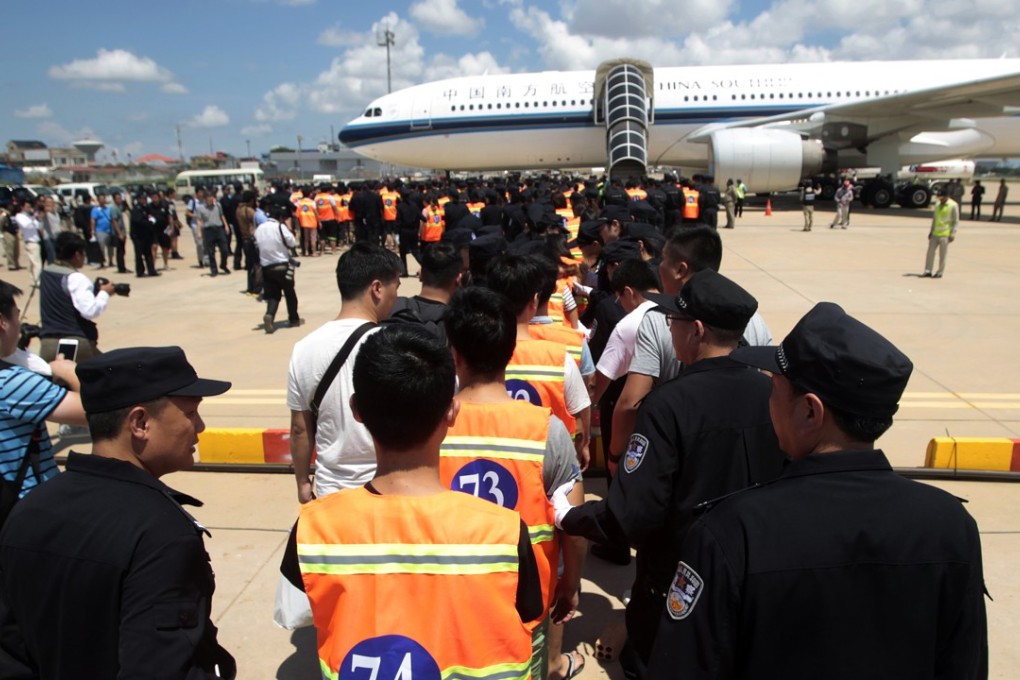 Chinese citizens suspected of an internet scam line up at Phnom Penh’s international airport to be deported. Photo: AP