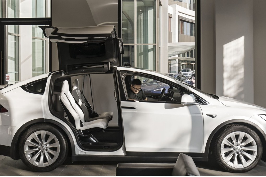 A customer sits inside a Tesla Model X at the company's showroom in Shanghai. Photo: Bloomberg
