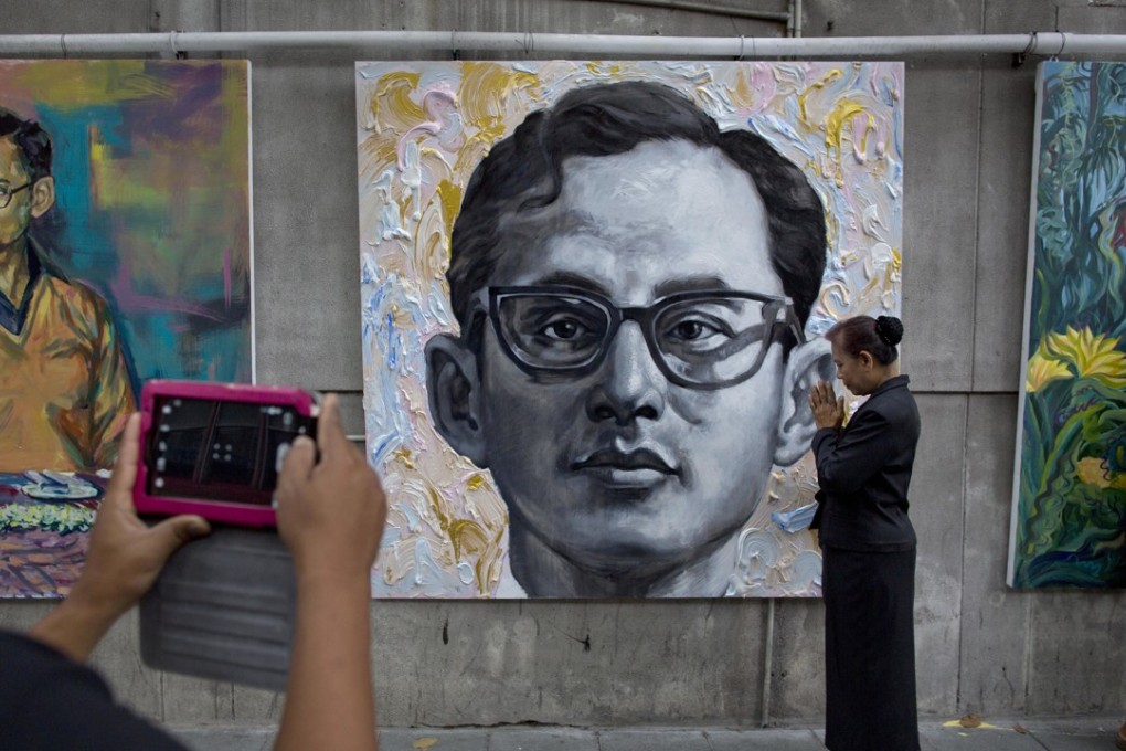 Mourners pay their respects by portraits of the late King Bhumibol Adulyadej. Photo: AP