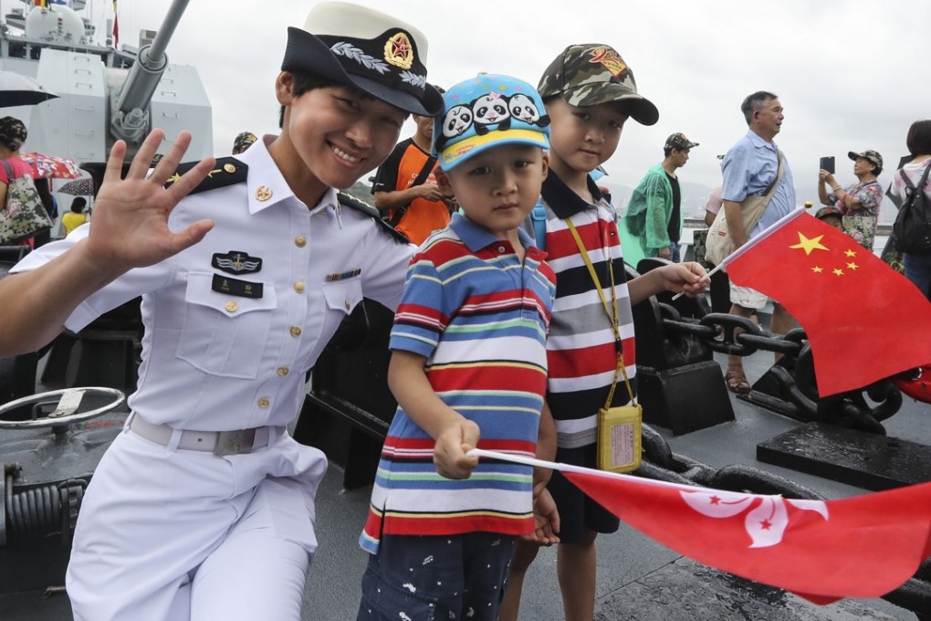 A PLA Navy soldier meets visiting children during an open day at Stonecutters Island in Hong Kong in July. Photo: Edward Wong
