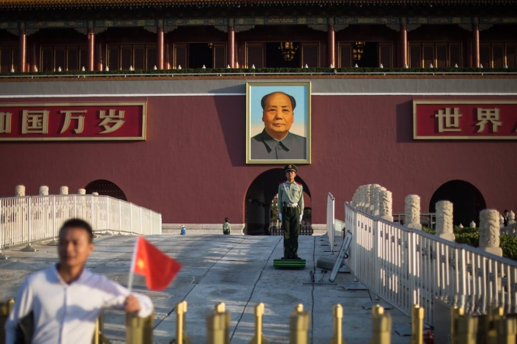 A visitor poses for photos in front of a portrait of Mao Zedong on the south gate of the Forbidden City in Beijing last month. Security is tight in the capital ahead of the party congress next week. Photo: EPA