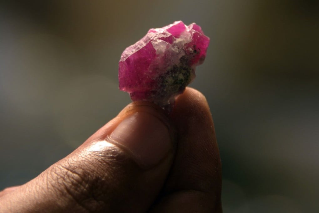 An employee of Azad Kashmir Mineral and Industrial Development Corporation (AKMIDC) shows a ruby gemstone. Photo: AFP