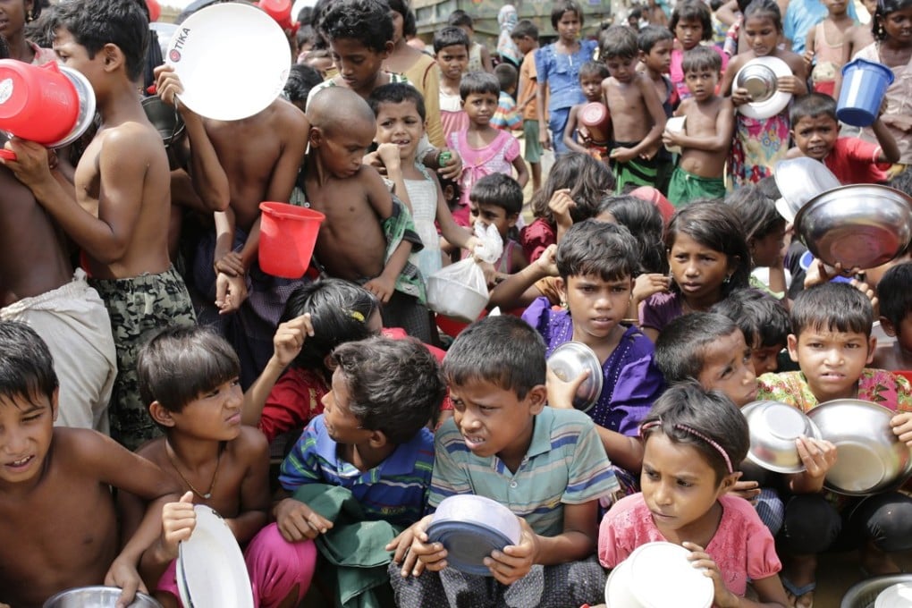Rohingya children wait outside a food centre to collect their lunch at a camp in Palonkhali, Cox’s Bazar, Bangladesh. Photo: EPA