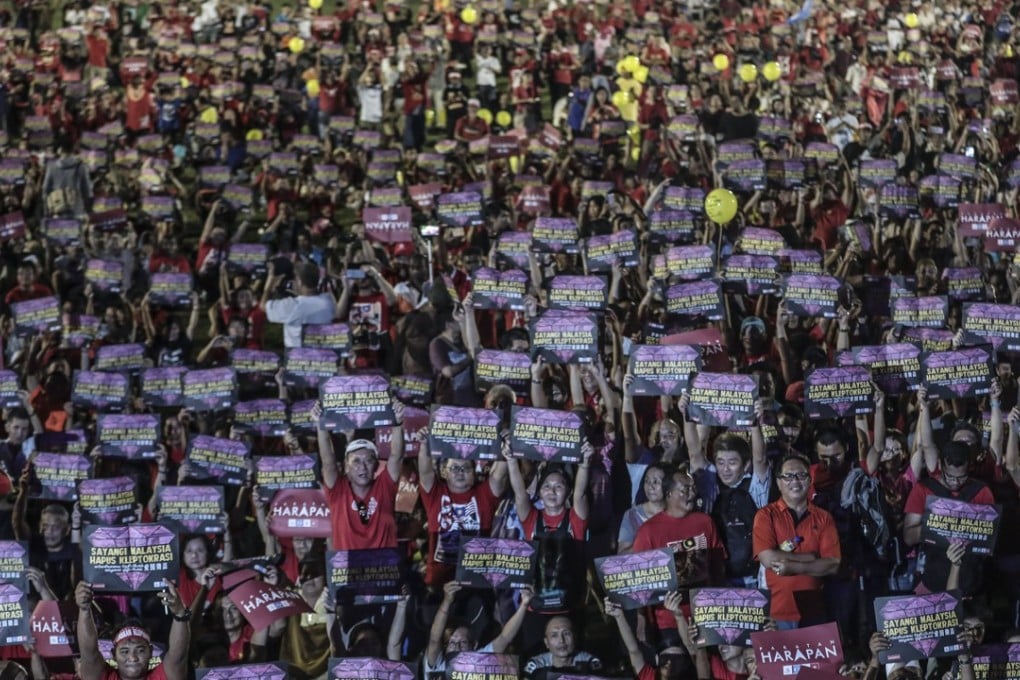 Malaysians hold placards during the anti-kleptocracy rally in Petaling Jaya, outside Kuala Lumpur. Photo: EPA