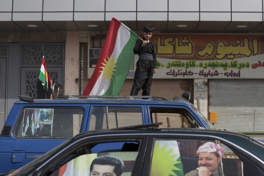A young boy carries a Kurdish flag on top of a car in the disputed city of Kirkuk, Iraq. Federal forces have started to move in on the city, which lies in the heart of Iraq’s oil-rich region. Photo: AP