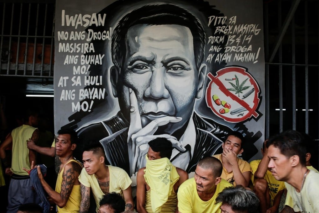 Inmates wait for clearance next to an image of Philippine President Rodrigo Duterte during a surprise inspection by the Bureau of Jail Management and Penology at Manila City Jail. Photo: EPA
