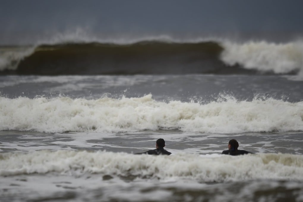Surfers watch waves whipped up by Hurricane Ophelia in the County Clare town of Lahinch, Ireland. Photo: Reuters