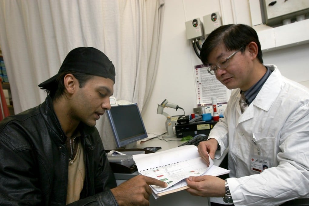 Doctor Victor Choi Sze-kwong, of the Yau Ma Tei Jockey Club General Out-patient Clinic, asks a patient to indicate his nationality so an interpretor can be provided before examination. Photo: K.Y. Cheng