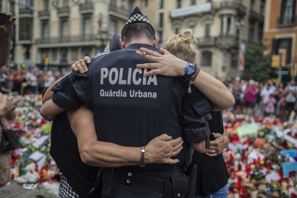 A policeman hugs a boy and his family that he helped during the terrorist attack in Las Ramblas, Barcelona. Photo: AP