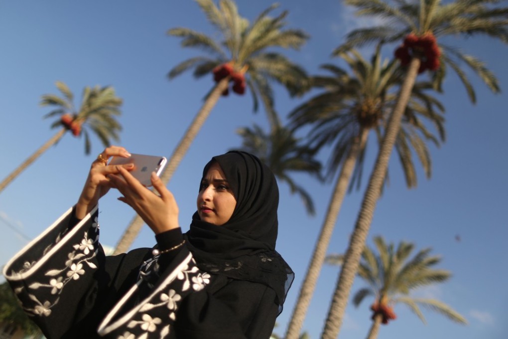 Palestinian Fatma Mosabah uses her mobile phone to take pictures for her social media account in Deir al-Balah in the central Gaza strip. Photo: AFP