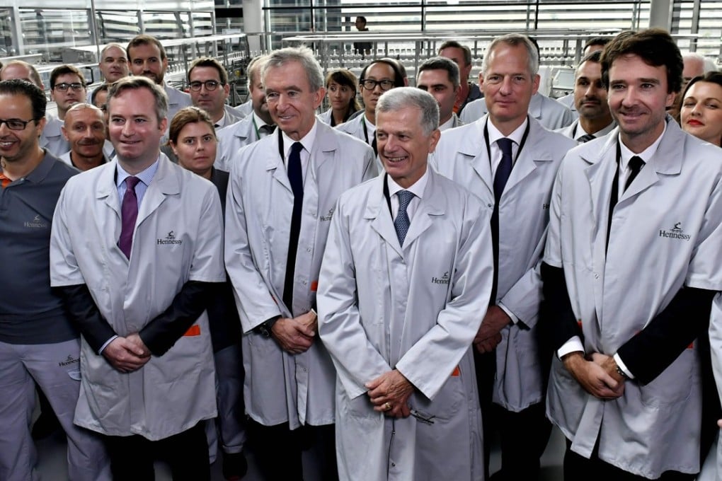 In white coats from left: French Junior Minister for Foreign Affairs Jean-Baptiste Lemoyne, Hennessy chairman and CEO Bernard Peillon, LVMH CEO Bernard Arnault, Moet Hennessy CEO Philippe Schaus and Antoine Arnault visit Hennessy’s new bottling plant. Photo: AFP