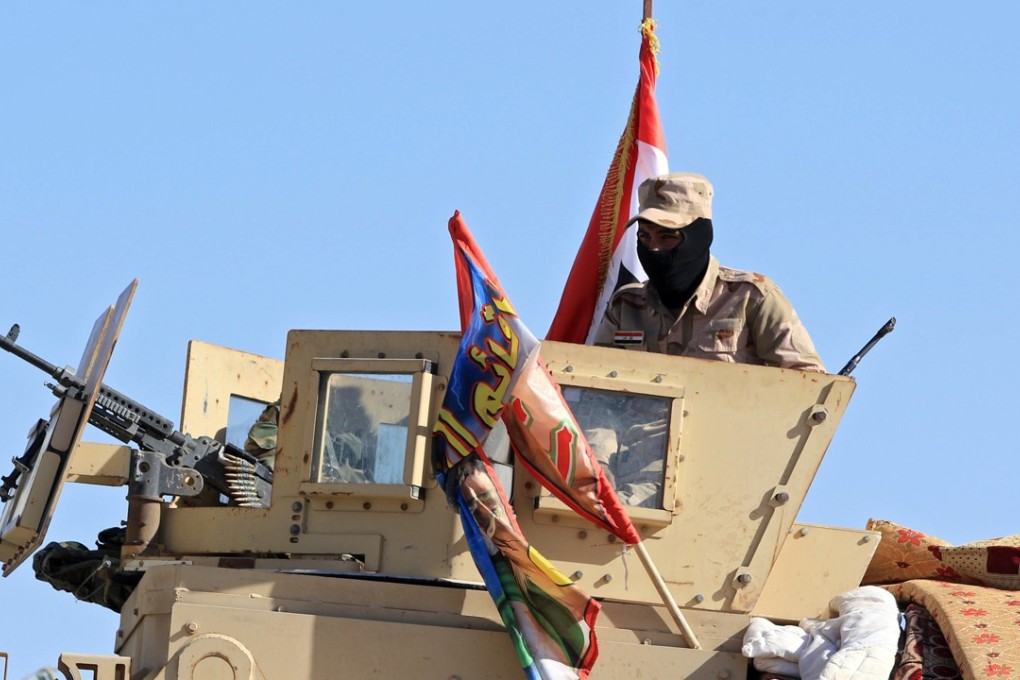 Iraqi soldiers ride in military vehicles in Zumar, Nineveh province, Iraq, as they grabbed control of most of the disputed area from retreating Kurds. Photo: Reuters