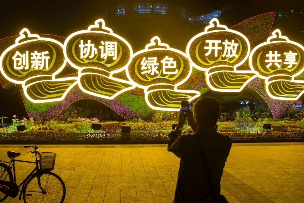 A man takes pictures of a display of Chinese characters representing the leadership's “Five Major Development Concepts” ahead of the 19th Party Congress in Beijing, on September 27. The characters read: “Innovation, Coordination, Green, Openness and Sharing”. Photo: Reuters
