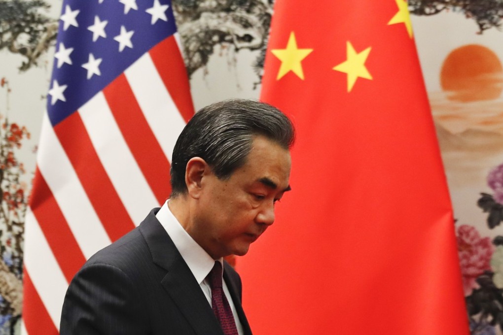 Chinese foreign minister Wang Yi walks past the US and Chinese national flags as he prepares to meet US Secretary of State Rex Tillerson at the Great Hall of the People in Beijing on September 30. Photo: EPA-EFE