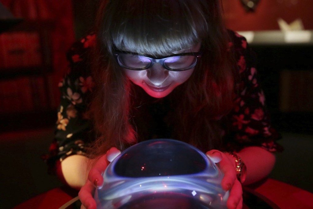 A member of British Library staff poses with a crystal ball for a picture at the “Harry Potter – A History of Magic” exhibition at the British Library in London. The exhibit opens on Friday. Photo: AP