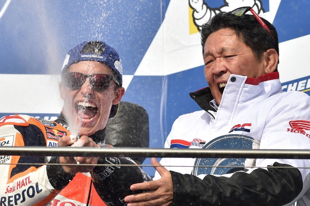 Honda rider Marc Marquez (L) celebrates his victory with Honda team boss Shuhei Nakamoto on the podium after the Australian MotoGP Grand Prix. Photo: AFP