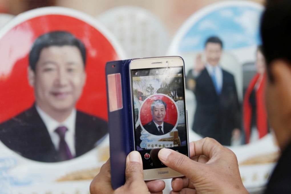 A tourist takes a picture of the souvenir plate with image of Chinese President Xi Jinping outside a shop next to Tiananmen Square. Photo: Reuters